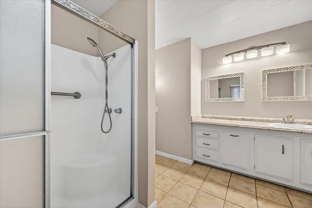 a bathroom with a shower sink and mirror