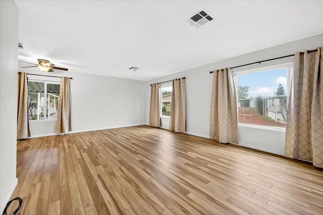 a view of an empty room with glass door and wooden floor