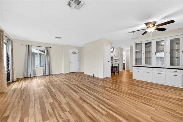 a view of empty room with wooden floor and windows
