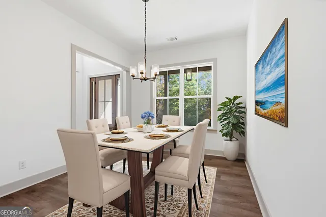 a view of an empty room with wooden floor fridge and a window