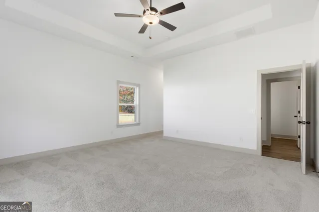 an empty room with closet and a ceiling fan