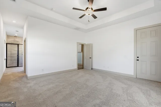 an empty room with closet and a ceiling fan