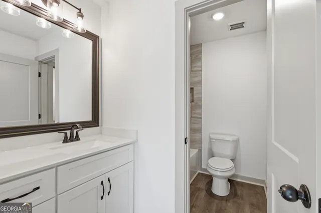 a bathroom with a toilet sink and mirror