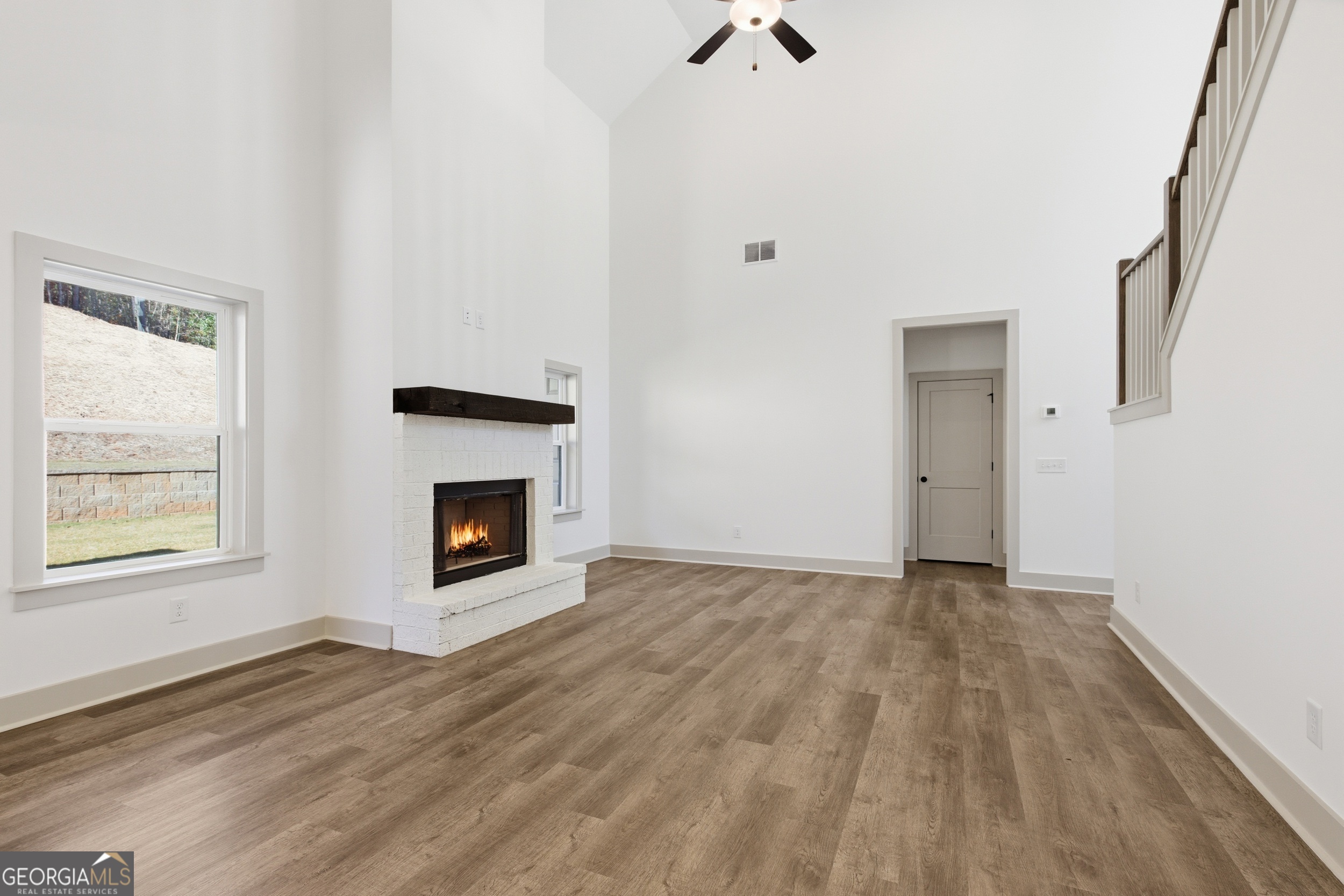 297 Ayers Creek Drive Toccoa, GA 30577 - Photo 9 of 51 an empty room with windows and a fireplace