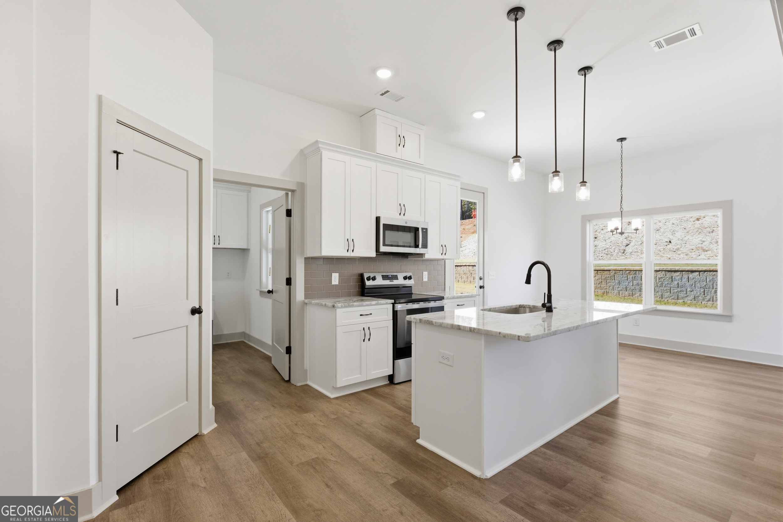 297 Ayers Creek Drive Toccoa, GA 30577 - Photo 10 of 51 a kitchen with stainless steel appliances kitchen island a refrigerator a stove a sink and a wooden floor