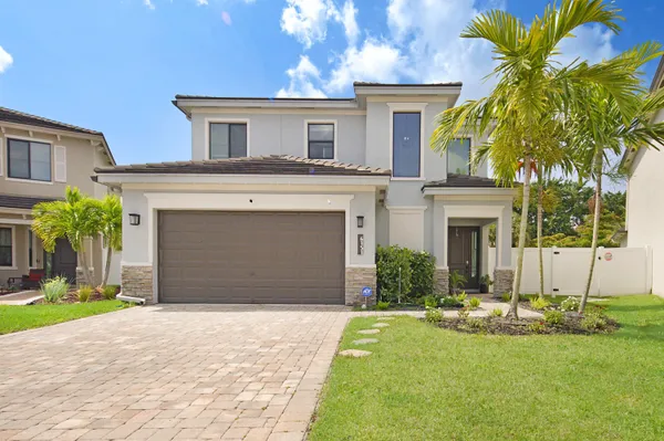a front view of a house with a yard and garage