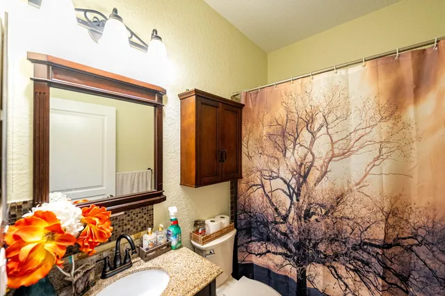 a bathroom with a toilet sink and mirror