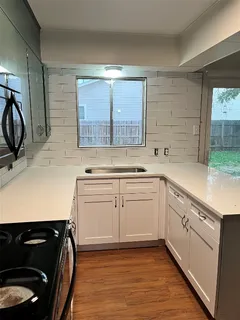 a kitchen with a sink stove and cabinets