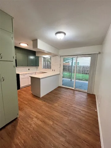 a view of kitchen with wooden floor and electronic appliances