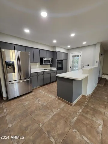 a large kitchen with stainless steel appliances lots of counter top space cabinets and a sink
