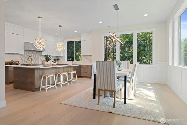 a dining room filled chandelier and kitchen view