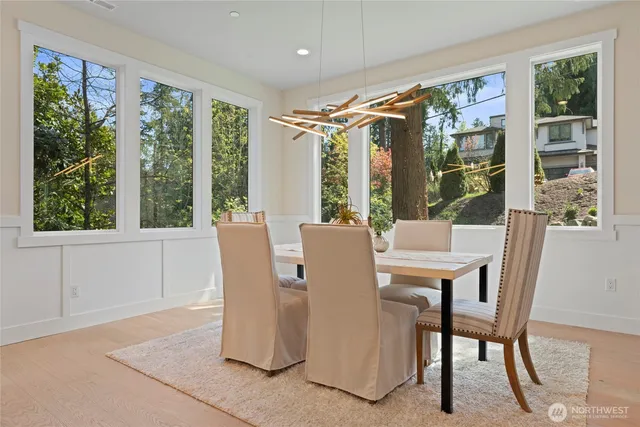 a view of a dining room with furniture large windows and wooden floor