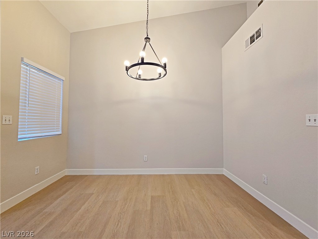 5370 Runningbrook Road Las Vegas, NV 89120 - Photo 13 of 30 A striking chandelier hangs elegantly above durable laminate flooring, completing this versatile interior space.