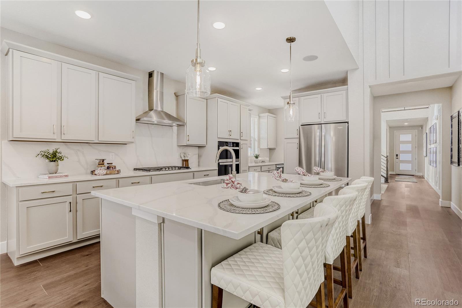 5386 Starling Way Firestone, CO 80504 - Photo 12 of 28 a kitchen with stainless steel appliances granite countertop a sink a stove a refrigerator and white cabinets with wooden floor