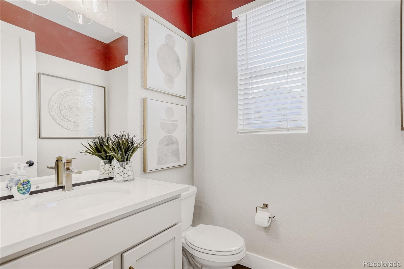 5386 Starling Way Firestone, CO 80504 - Photo 14 of 28 a bathroom with a sink a toilet a mirror and vanity