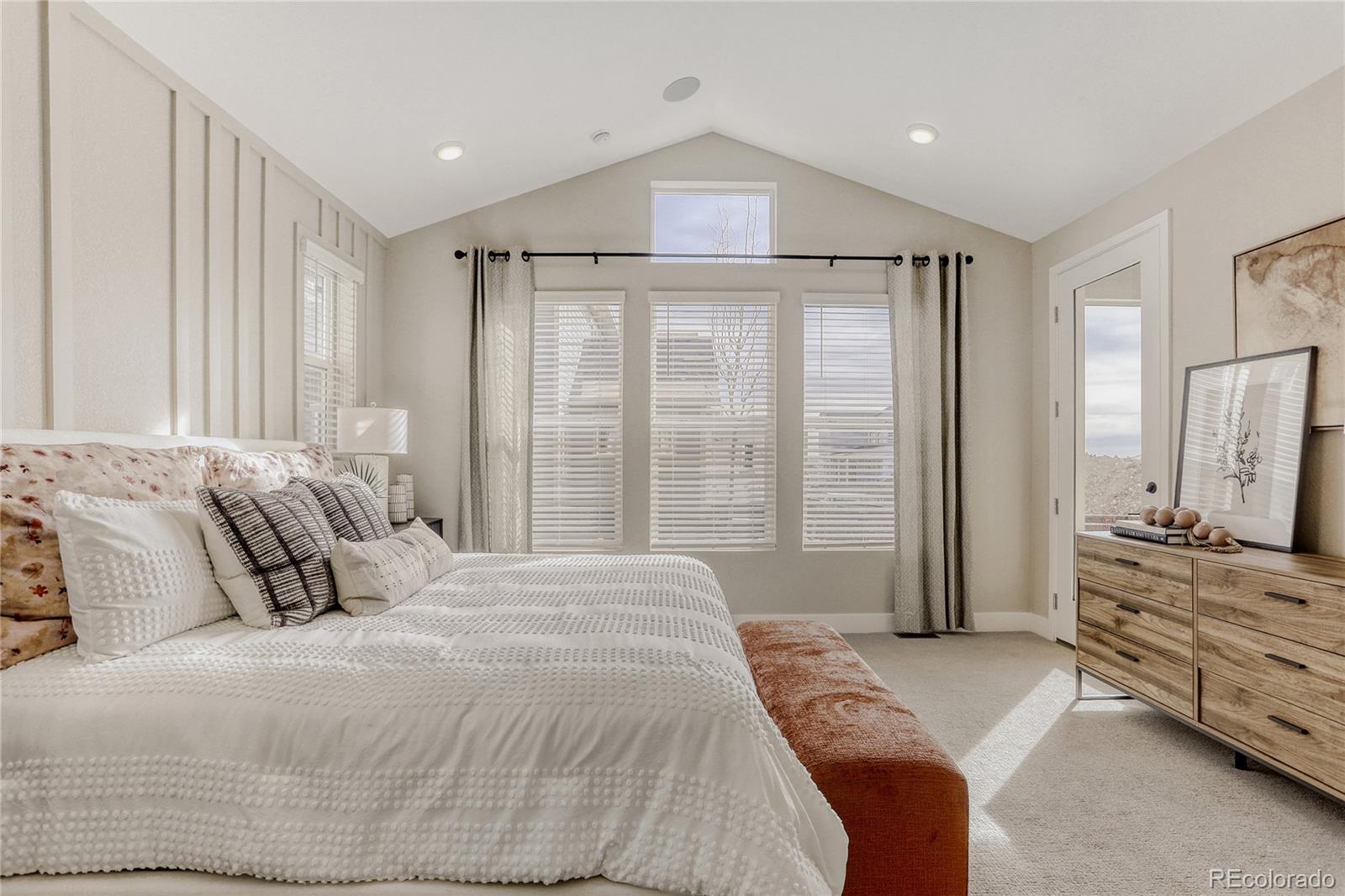 5386 Starling Way Firestone, CO 80504 - Photo 16 of 28 a bedroom with a bed and large windows