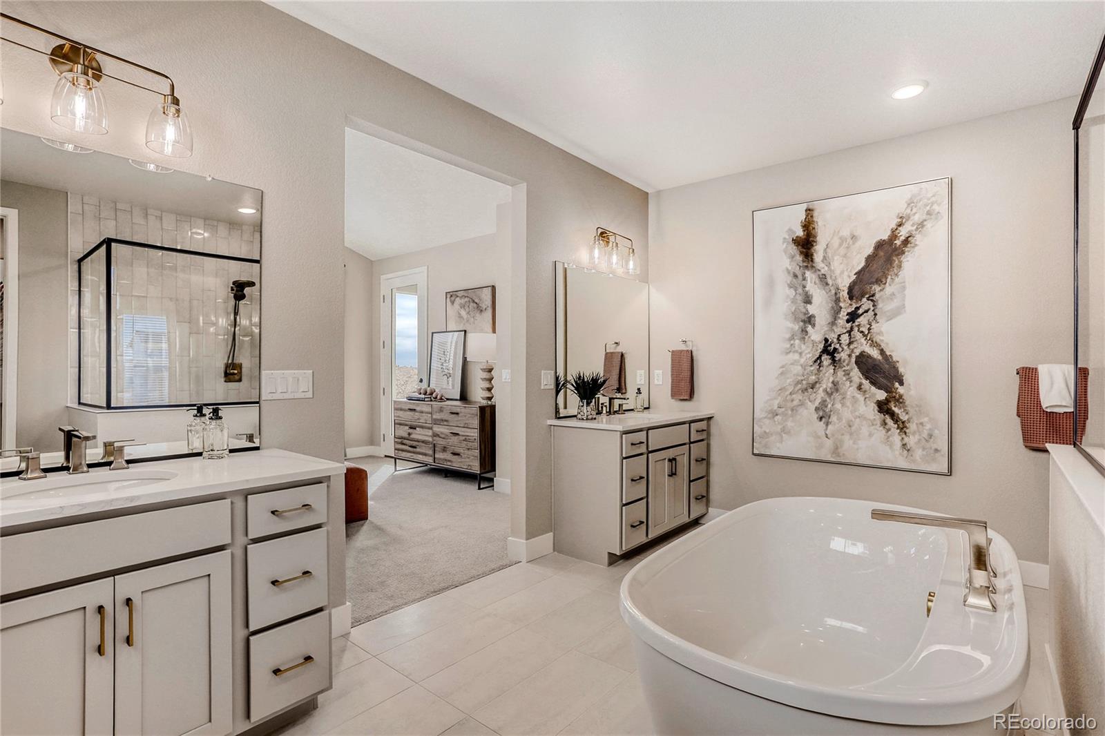 5386 Starling Way Firestone, CO 80504 - Photo 19 of 28 a spacious bathroom with a double vanity sink a mirror a bathtub and a shower