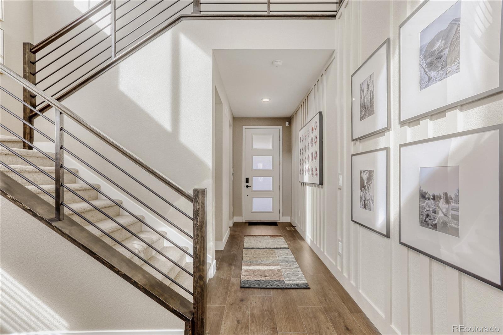5386 Starling Way Firestone, CO 80504 - Photo 5 of 28 a view of a hallway with wooden floor and staircase