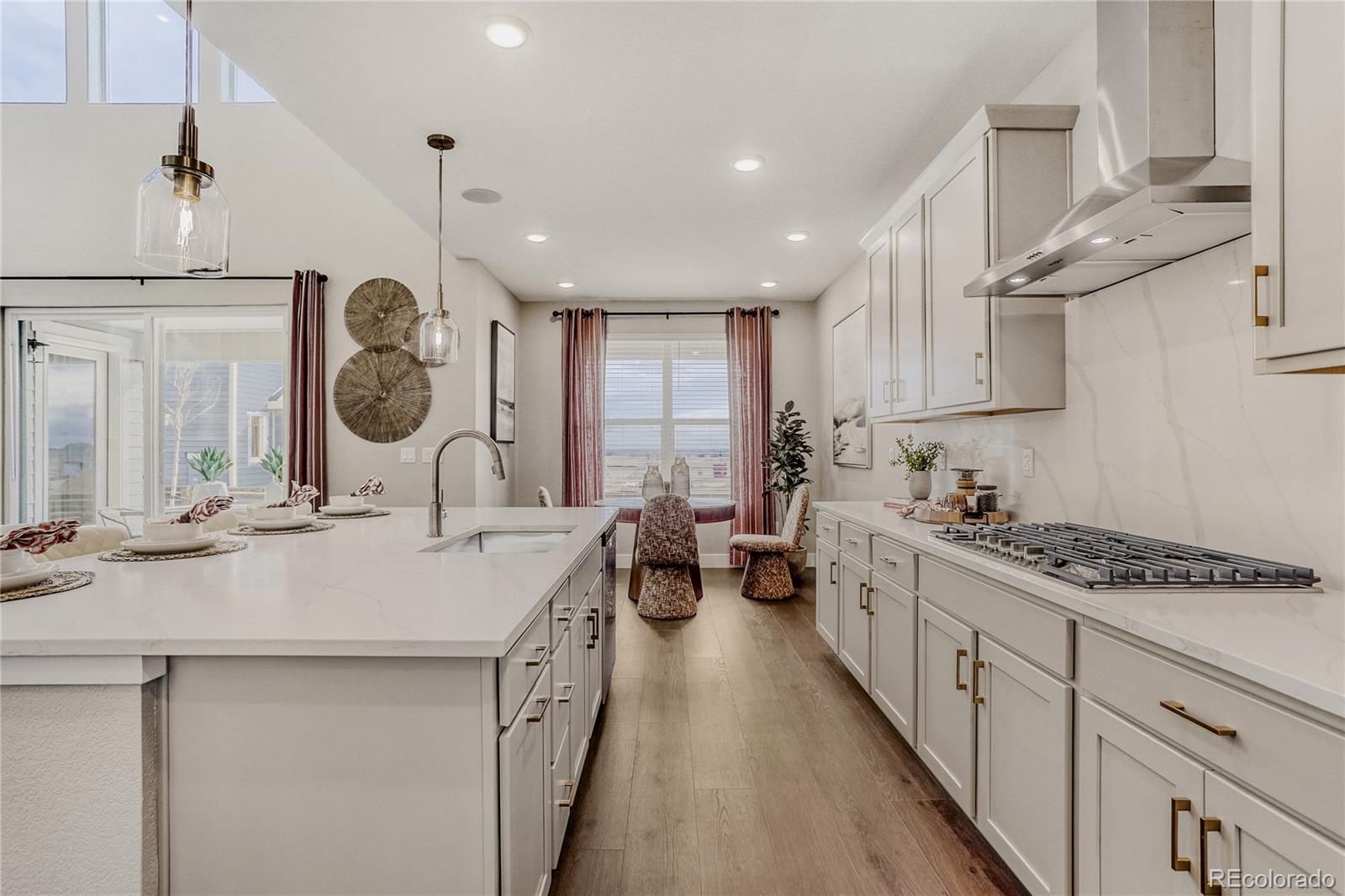 5386 Starling Way Firestone, CO 80504 - Photo 10 of 28 a kitchen with a sink a stove cabinets and wooden floor