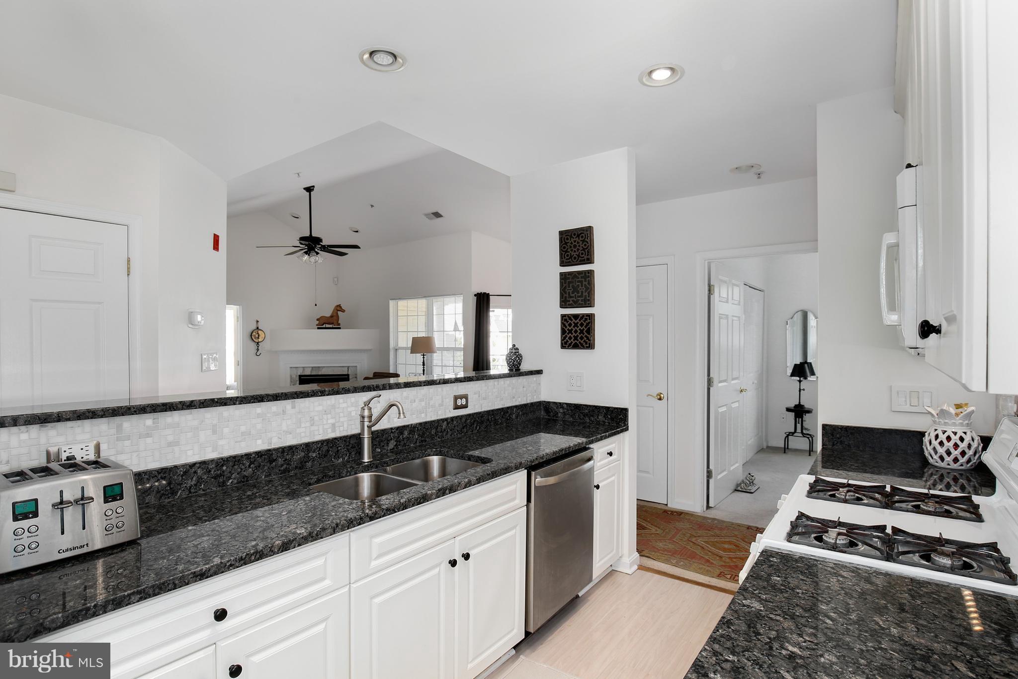 25272 Riffleford Square, Unit 304 Chantilly, VA 20152 - Photo 13 of 30 a kitchen with granite countertop a sink stove and cabinets
