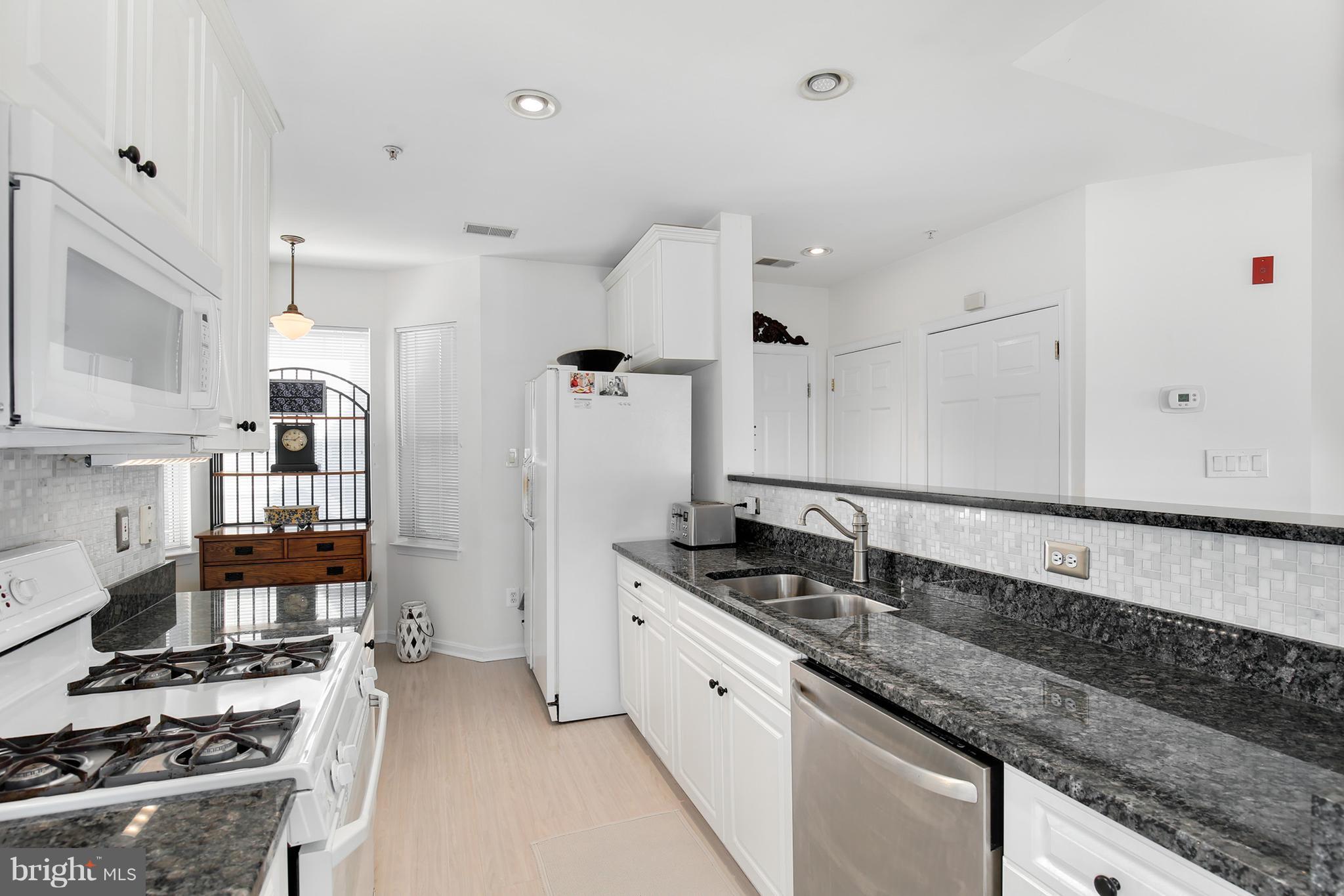 25272 Riffleford Square, Unit 304 Chantilly, VA 20152 - Photo 15 of 30 a kitchen with granite countertop a sink stainless steel appliances and cabinets