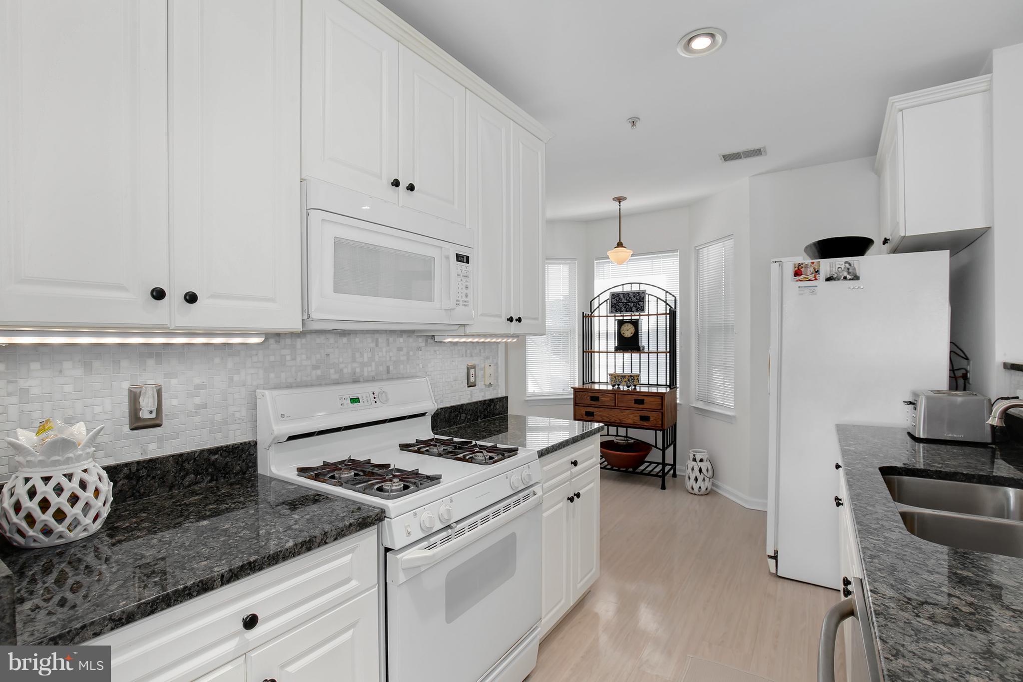 25272 Riffleford Square, Unit 304 Chantilly, VA 20152 - Photo 16 of 30 a kitchen with granite countertop a sink stove and cabinets