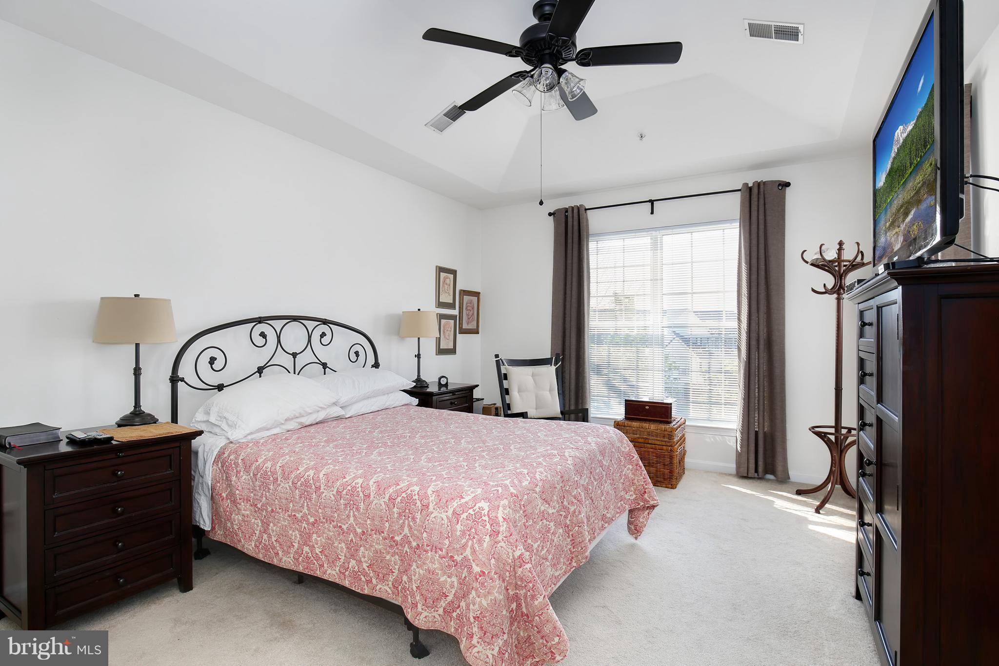 25272 Riffleford Square, Unit 304 Chantilly, VA 20152 - Photo 20 of 30 a bedroom with a bed a large mirror with a flat tv screen and dresser