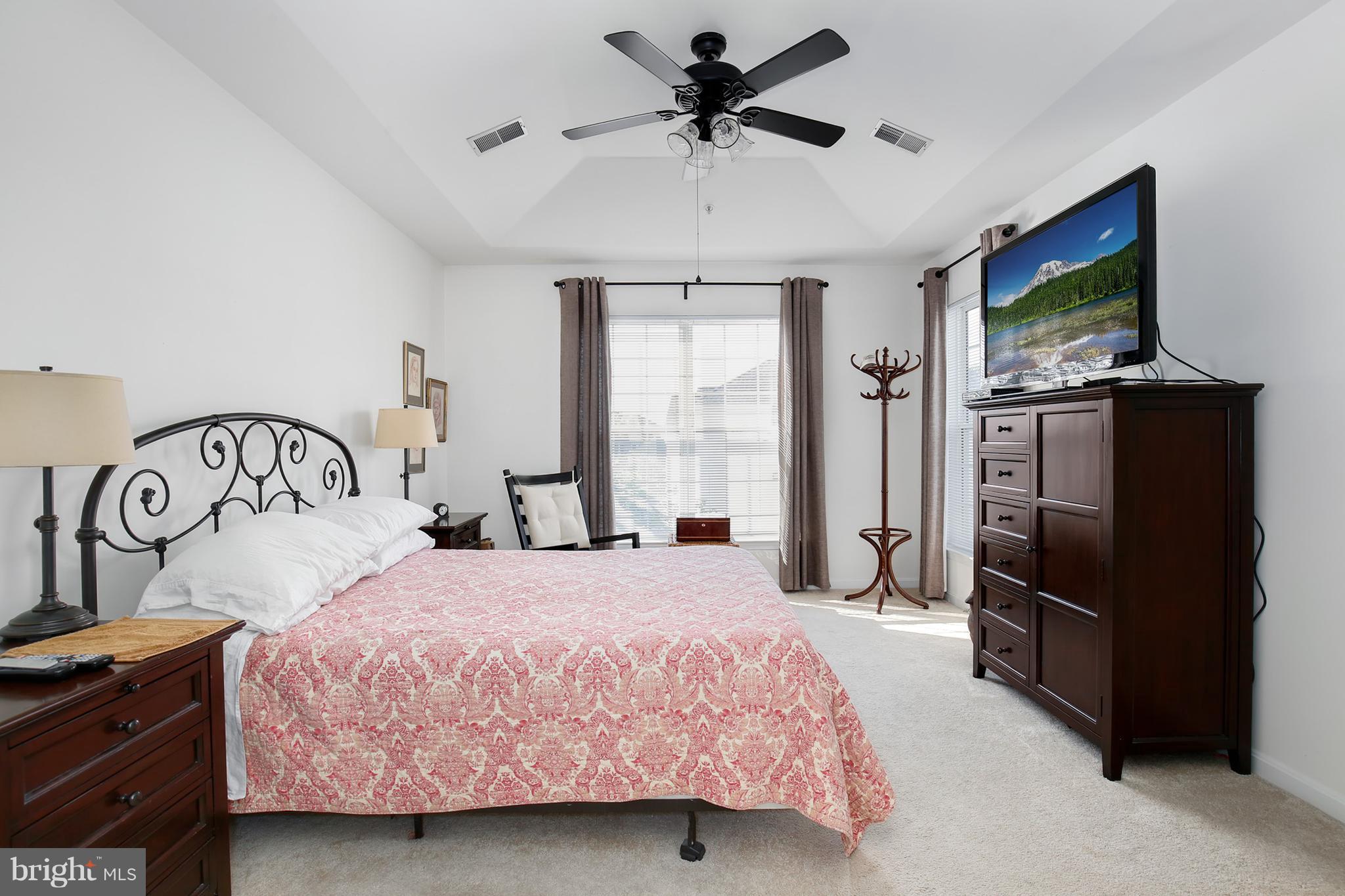 25272 Riffleford Square, Unit 304 Chantilly, VA 20152 - Photo 22 of 30 a bedroom with a bed and a flat tv screen on dresser