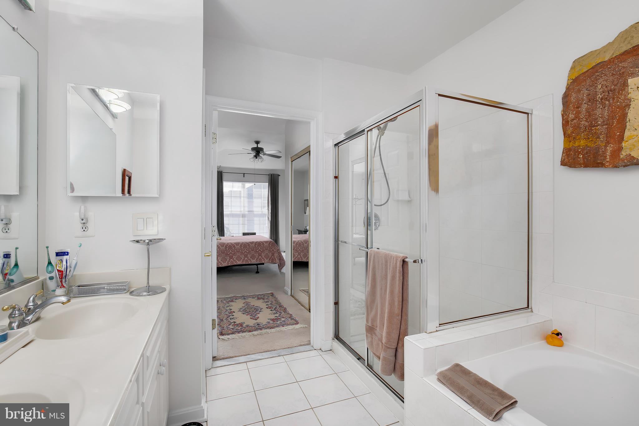 25272 Riffleford Square, Unit 304 Chantilly, VA 20152 - Photo 24 of 30 a bathroom with a granite countertop sink a mirror and shower