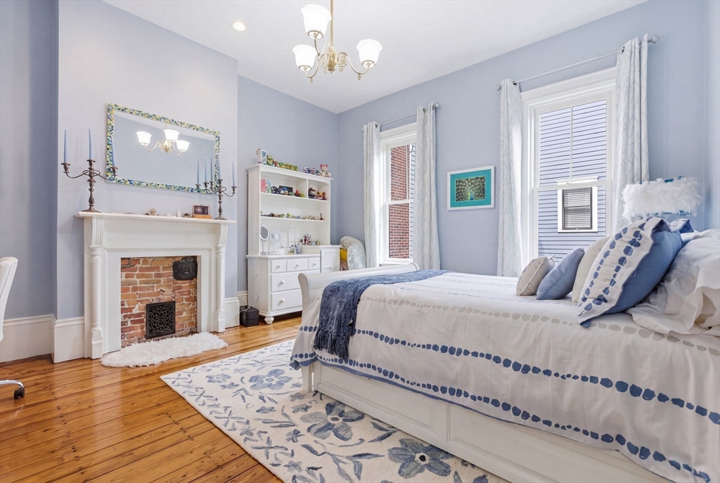 419 Main Street Boston, MA 02129 - Photo 16 of 41 a bedroom with a large bed and a fireplace
