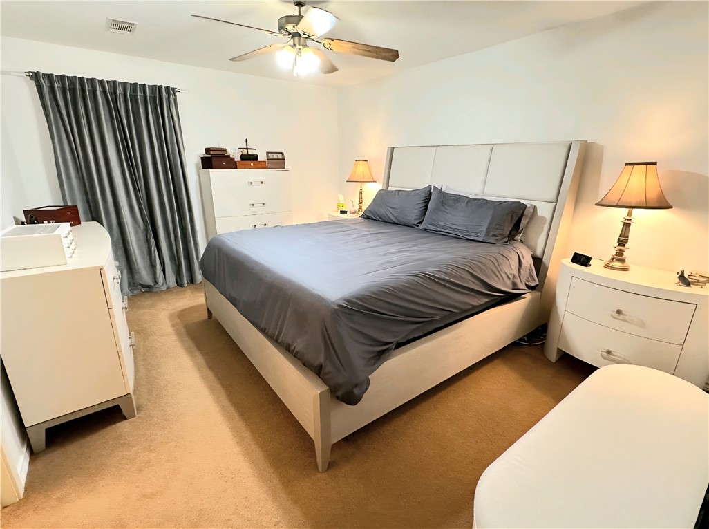 219 Ripple Creek Lane Somerville, TX 77879 - Photo 29 of 46 a spacious bedroom with a bed and a chandelier