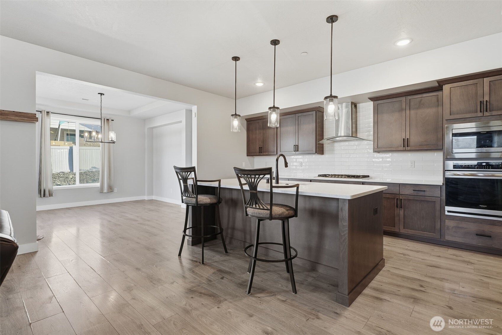 2572 Clark Ridge Drive Richland, WA 99352 - Photo 9 of 25 a open kitchen with stainless steel appliances granite countertop a stove top oven a refrigerator a sink dishwasher and white cabinets with wooden floor