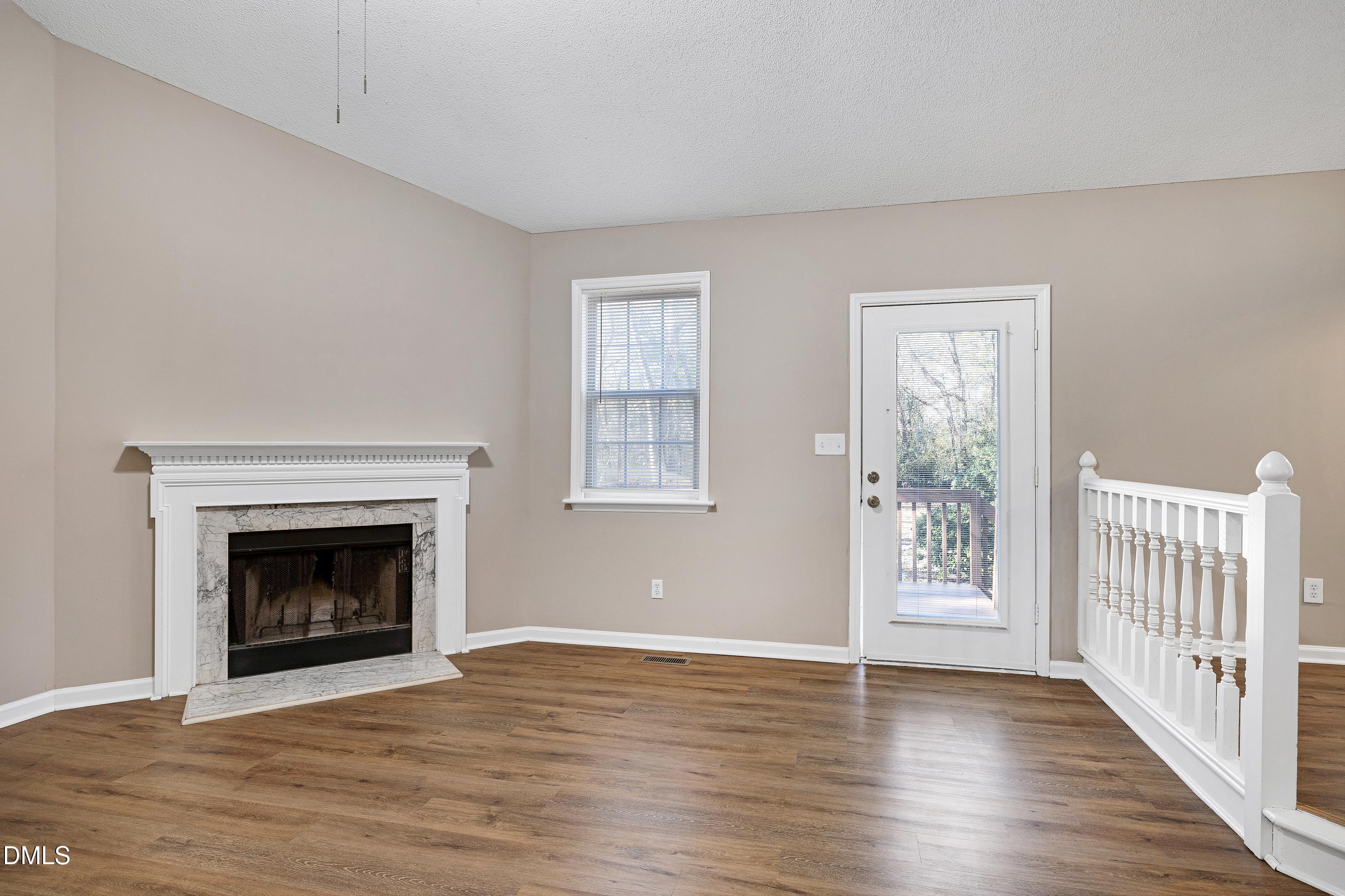 4100 Rockside Hills Drive Raleigh, NC 27603 - Photo 11 of 52 an empty room with wooden floor fireplace and windows