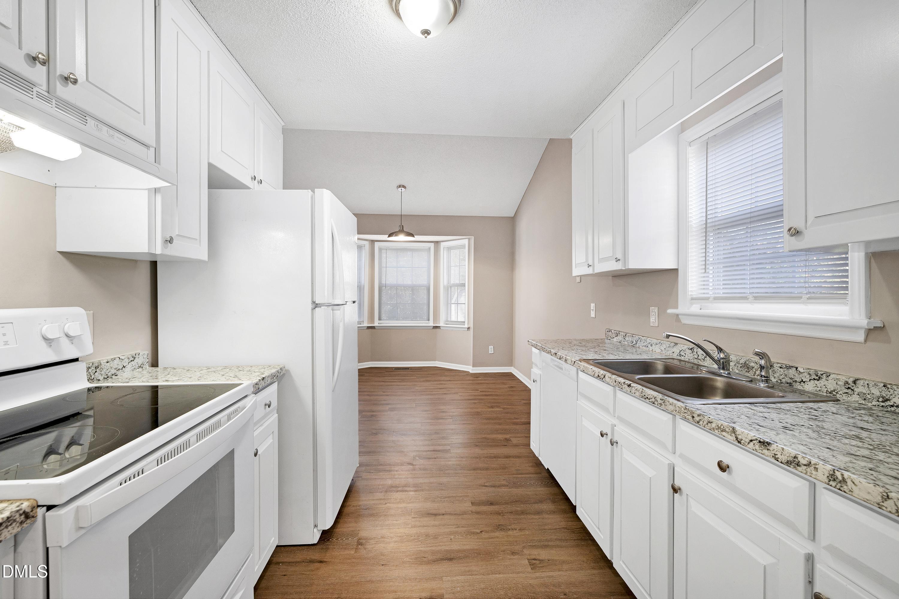 4100 Rockside Hills Drive Raleigh, NC 27603 - Photo 13 of 52 a kitchen with granite countertop a sink stove and refrigerator