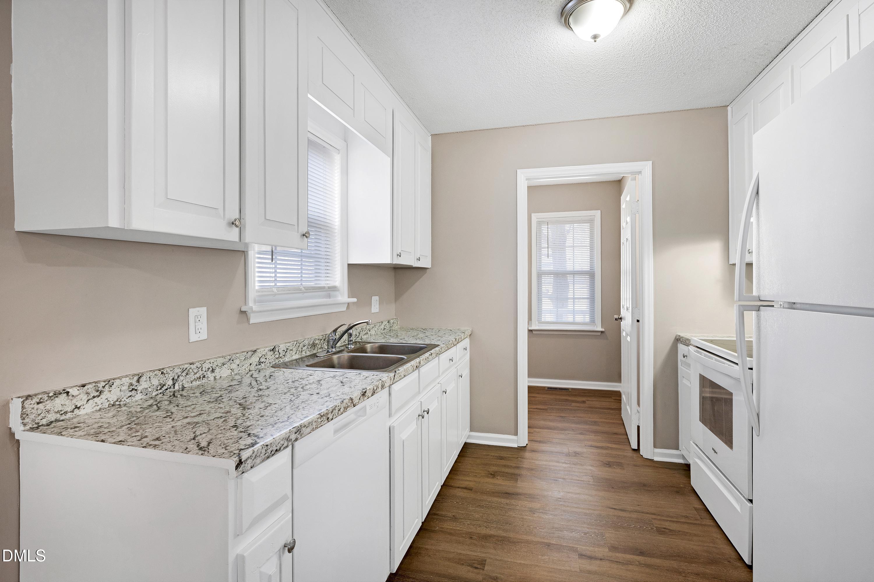 4100 Rockside Hills Drive Raleigh, NC 27603 - Photo 16 of 52 a kitchen with granite countertop white cabinets and white appliances