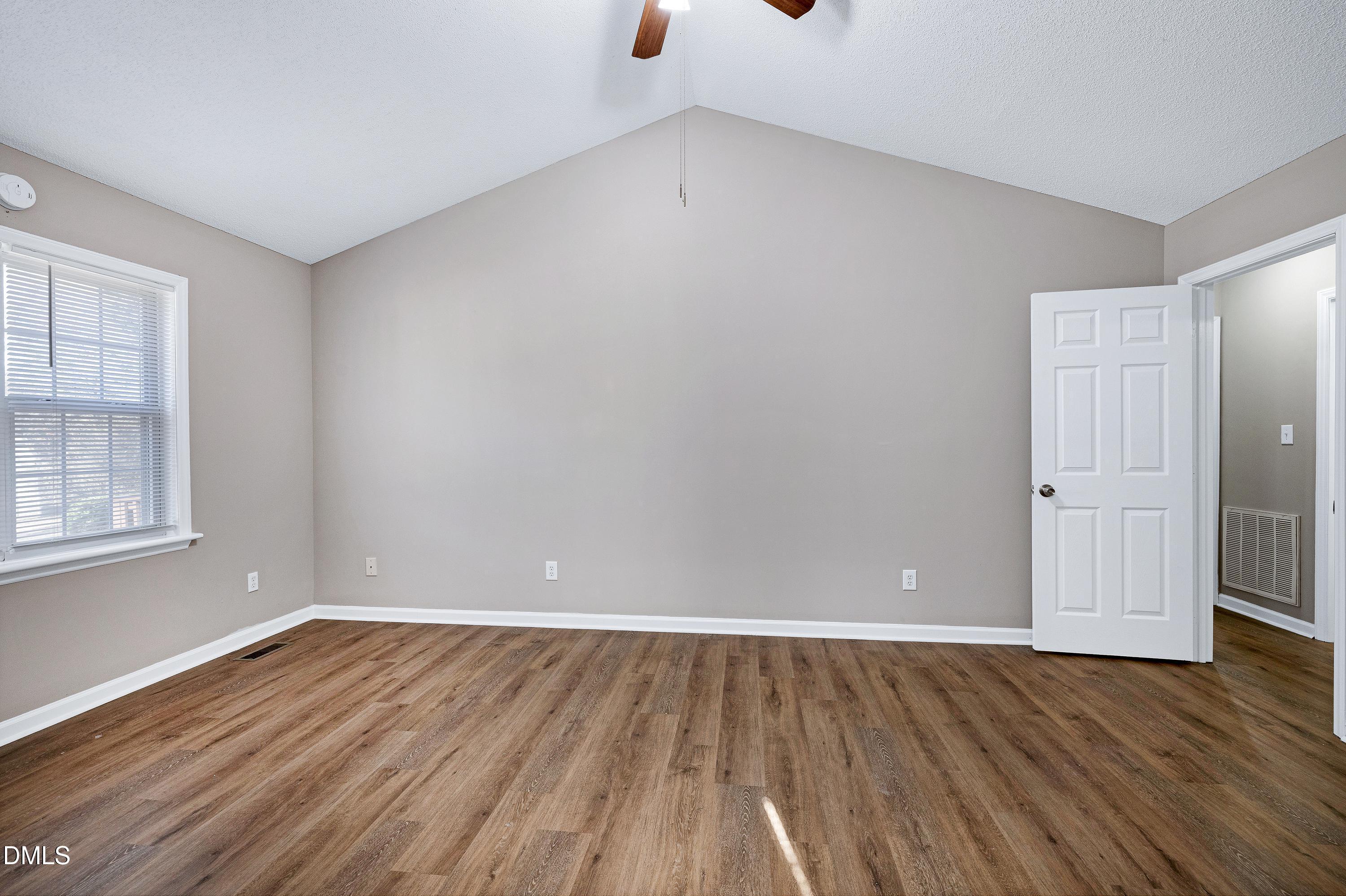 4100 Rockside Hills Drive Raleigh, NC 27603 - Photo 20 of 52 a view of an empty room with wooden floor and windows
