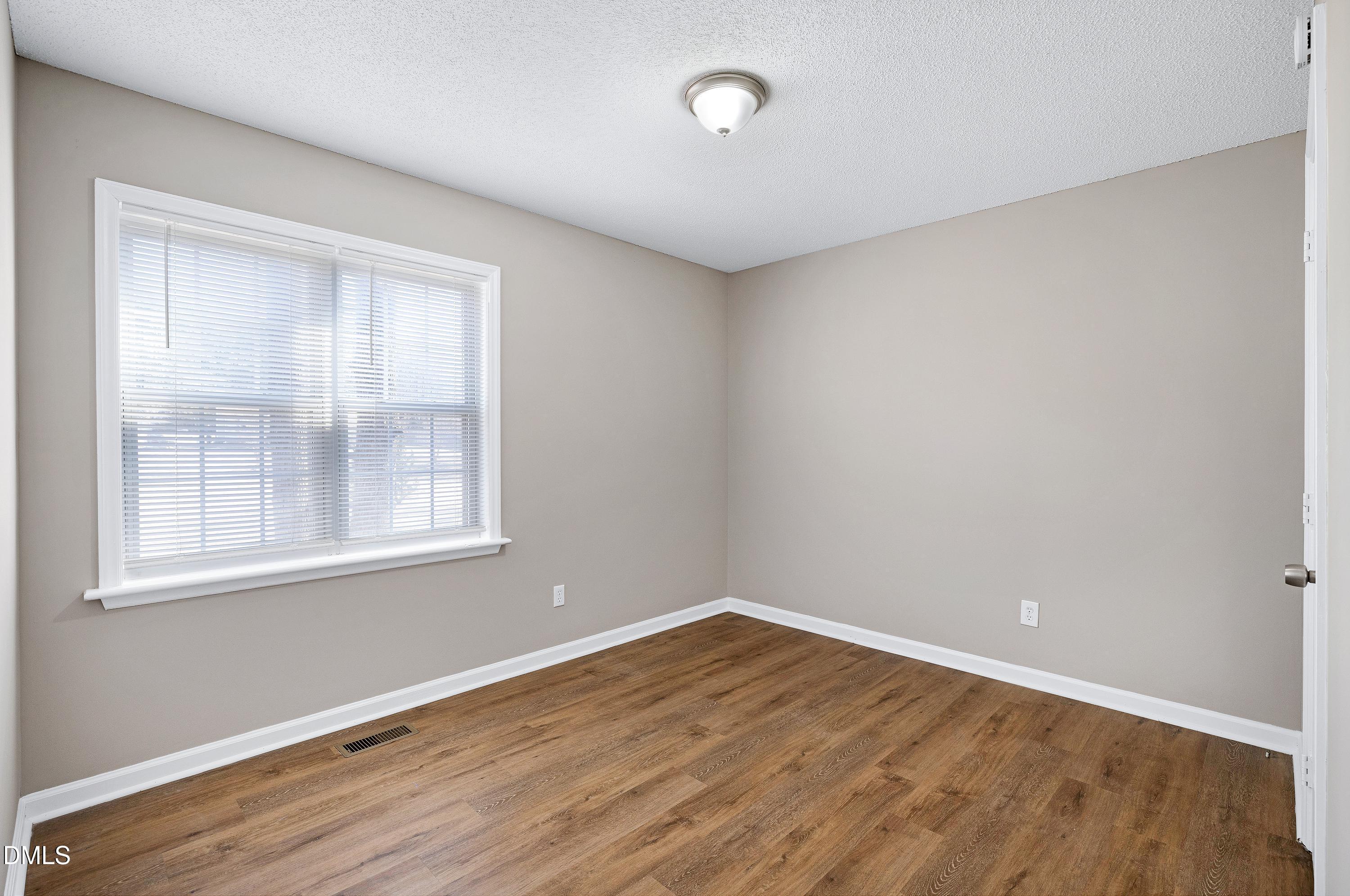 4100 Rockside Hills Drive Raleigh, NC 27603 - Photo 24 of 52 an empty room with wooden floor and windows