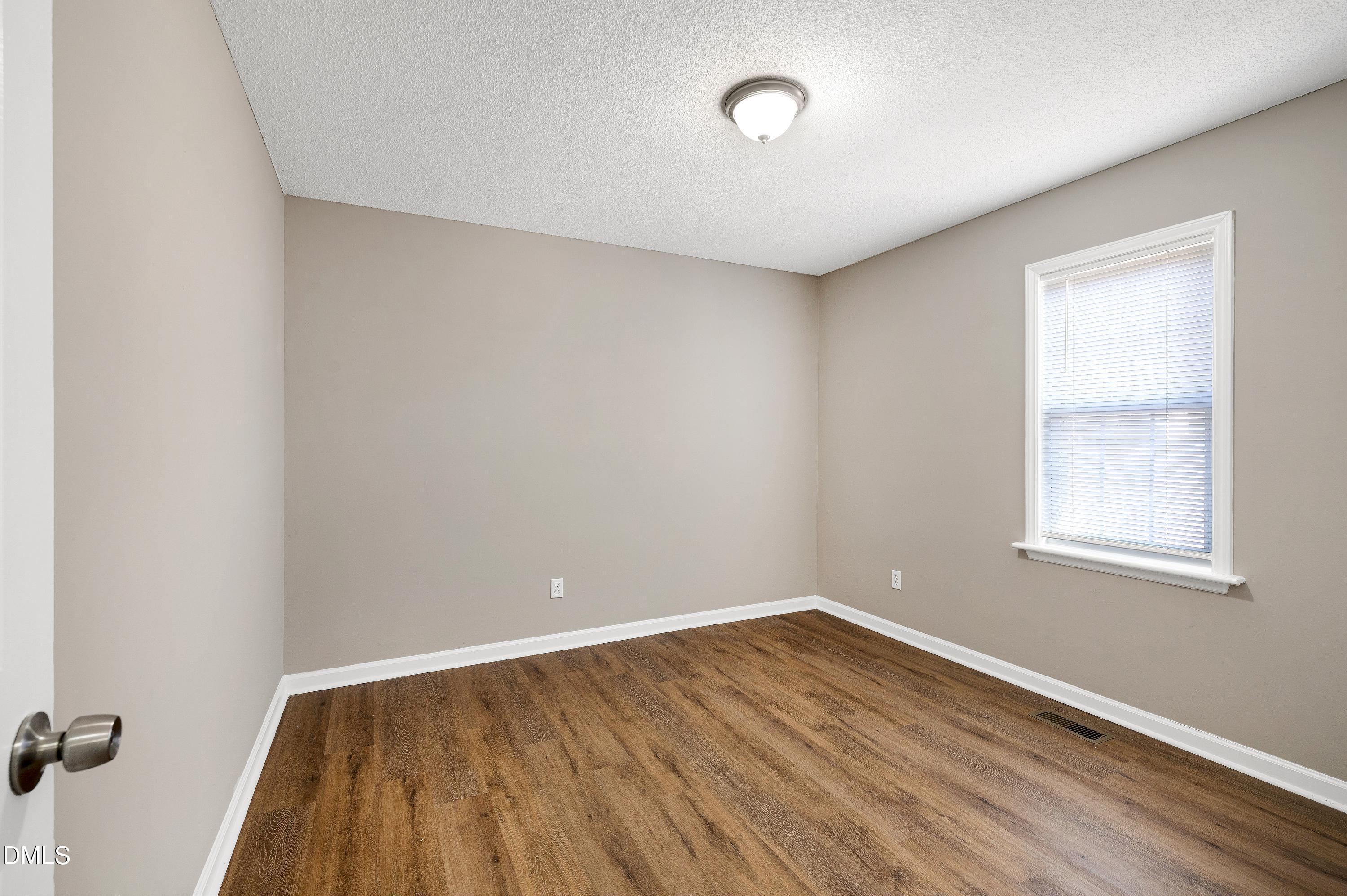 4100 Rockside Hills Drive Raleigh, NC 27603 - Photo 26 of 52 an empty room with wooden floor and windows
