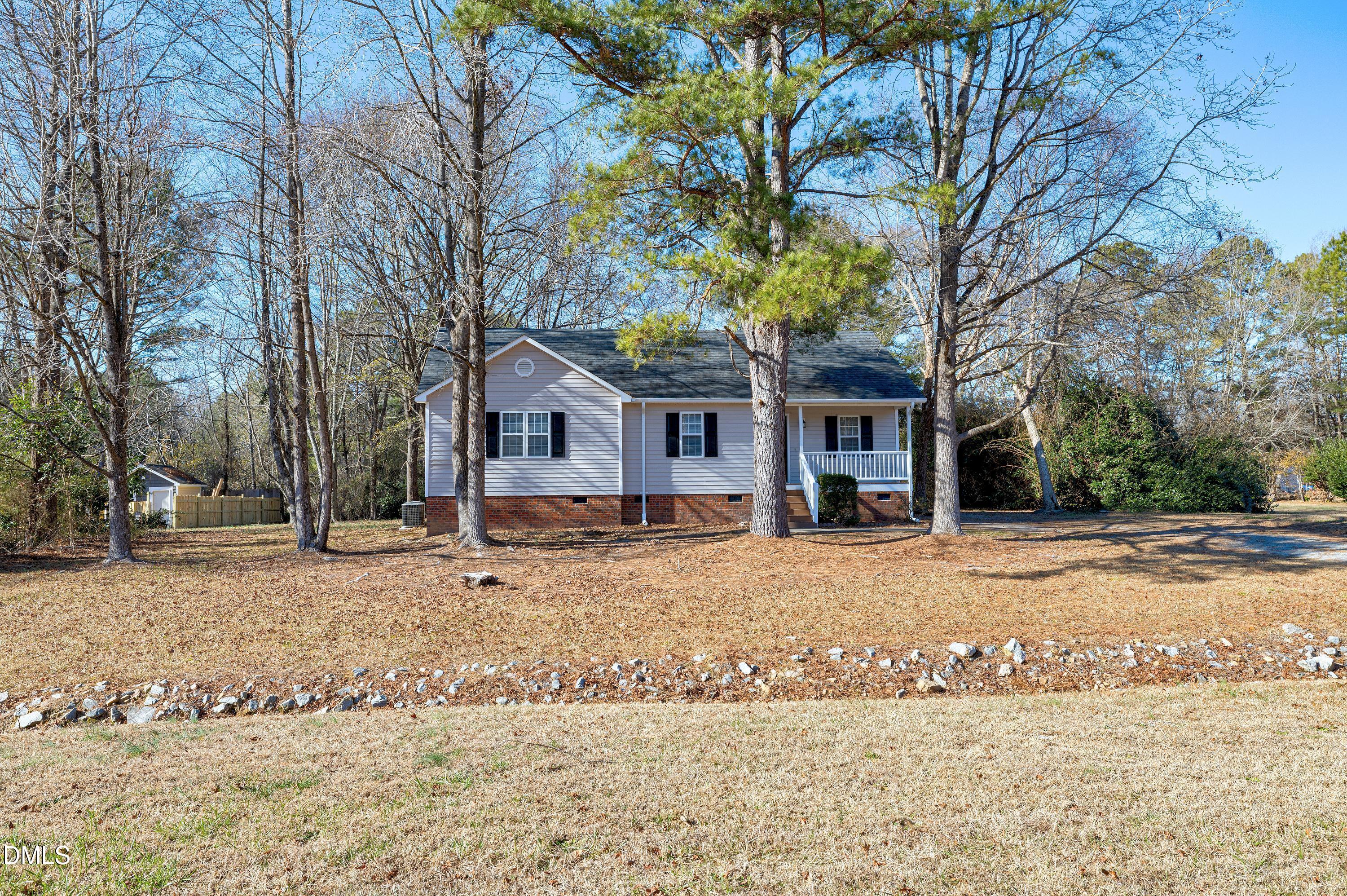 4100 Rockside Hills Drive Raleigh, NC 27603 - Photo 32 of 52 a front view of a house with a dirt yard and a large tree