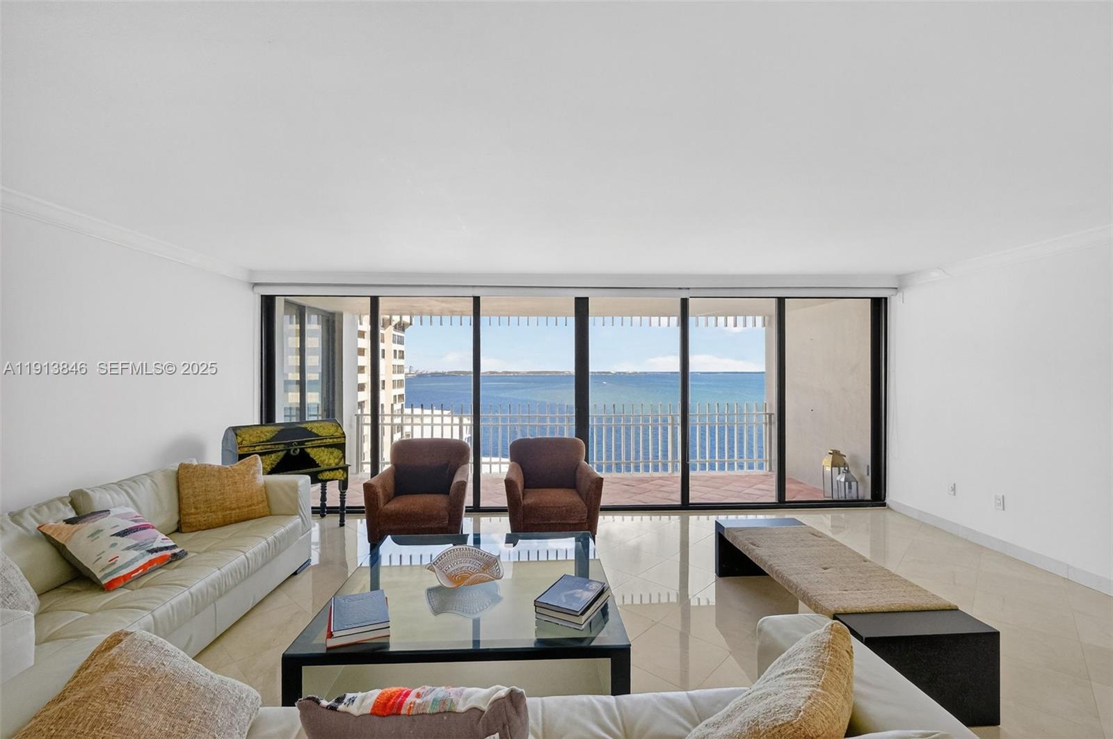 a living room with furniture and floor to ceiling windows