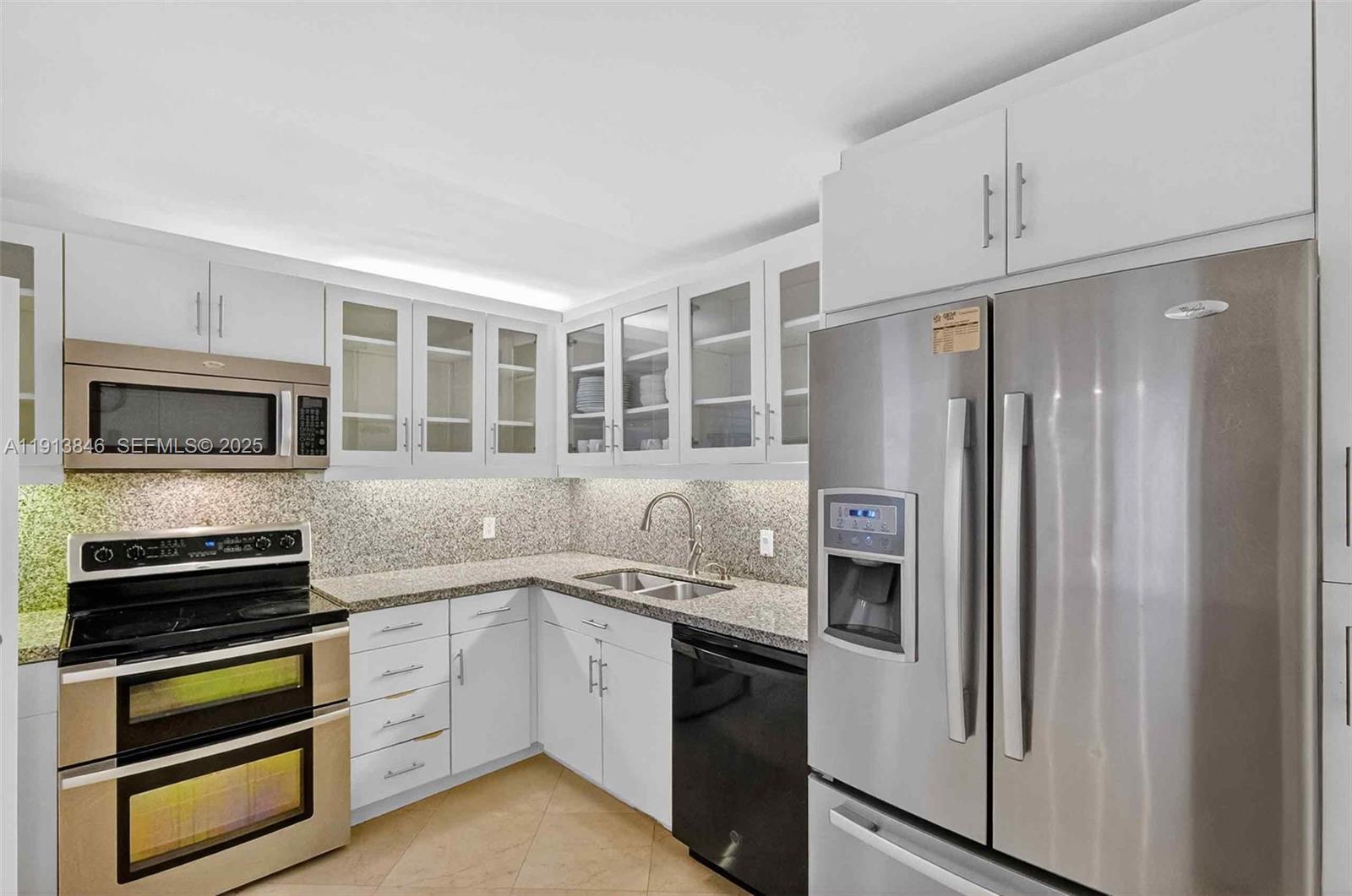 2 Grove Isle Drive, Unit B1505 Miami, FL 33133 - Photo 12 of 51 a kitchen with stainless steel appliances granite countertop a refrigerator and a stove top oven