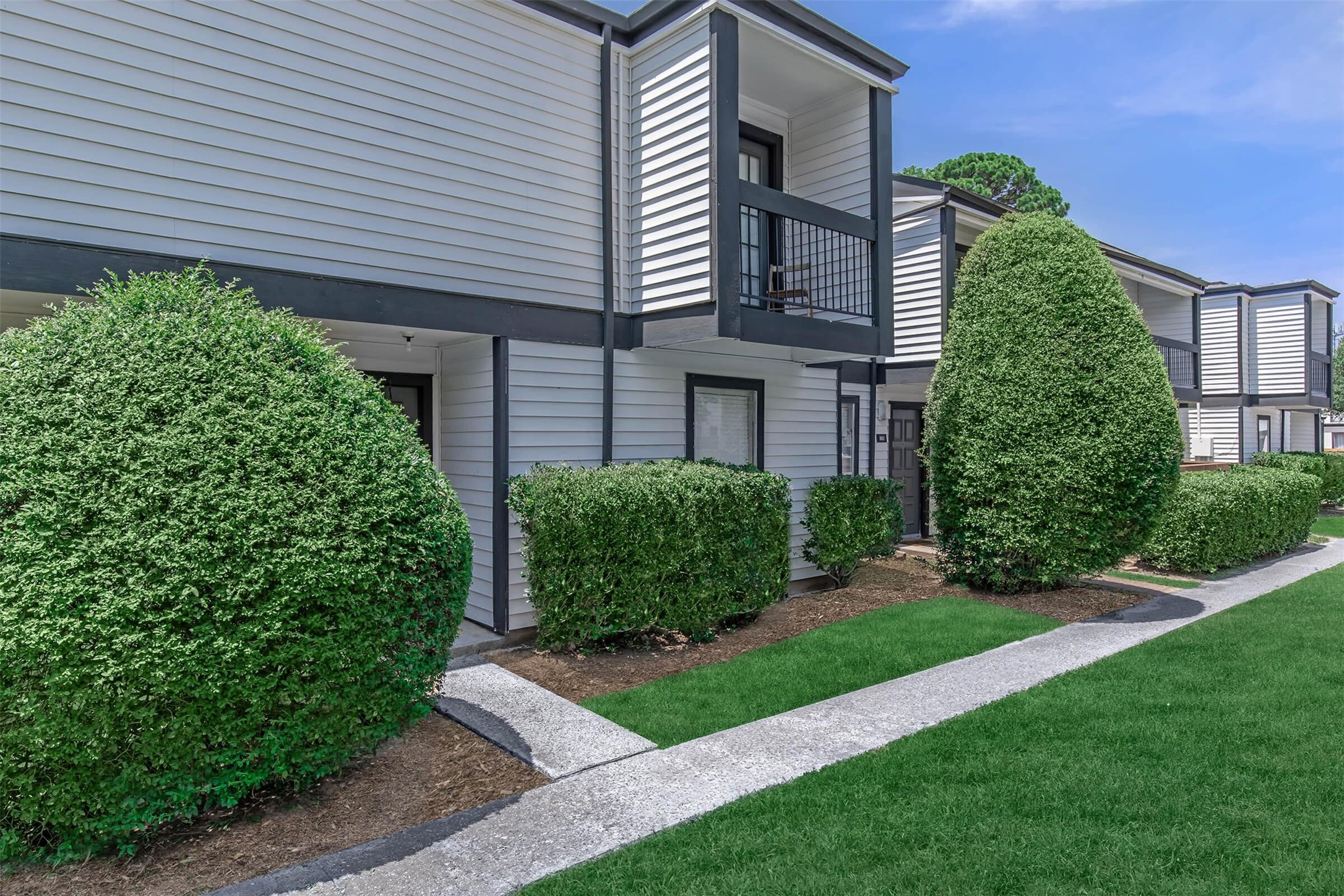 18001 Cypress Trace Road, Unit 603 Houston, TX 77090 - Photo 27 of 32 a view of a house with brick walls and a yard with plants