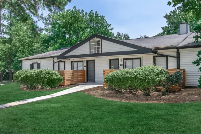 a front view of a house with a yard and green space