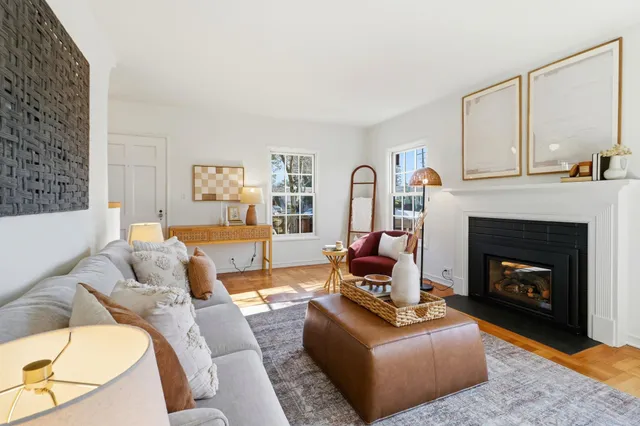a living room with furniture fireplace and a large mirror