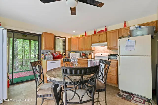 a dining room with furniture a chandelier and a floor to ceiling window