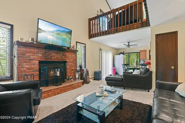 a living room with furniture a flat screen tv and a fireplace