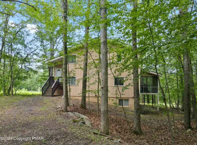 a view of a brick house with large trees