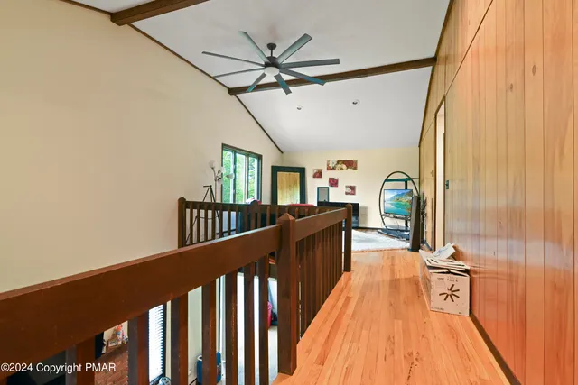 a view of a hallway with wooden floor and staircase