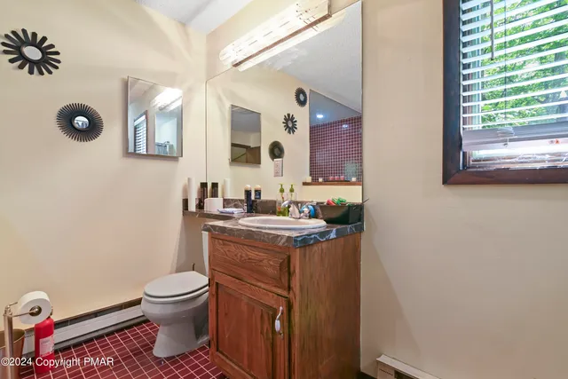 a bathroom with a granite countertop toilet sink and mirror