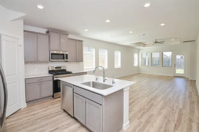 a kitchen with white cabinets stove and kitchen island